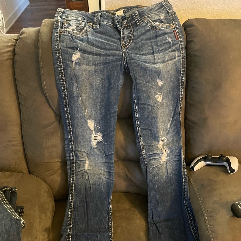 Tattered distressed silver jeans